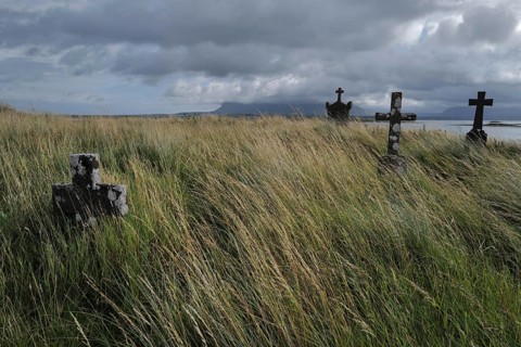 Crosses in a deserted graveyard along the seaside with Ben Bulben in the distant background. Sligo,