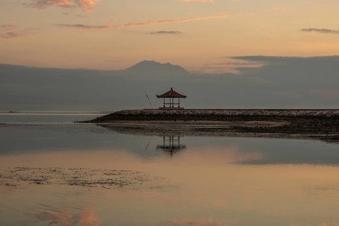 Beautiful seascape in the morning. Tropical sandy beach with breakwater and reflection of the sky