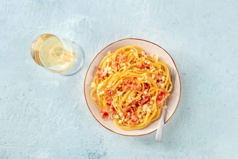 Carbonara pasta dish, traditional Italian spaghetti with pancetta and cheese, with wine, and a