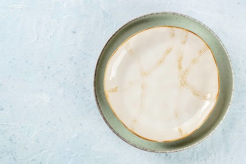 An empty plate with a gold rim, shot from above on a slate background with a place for text, Food