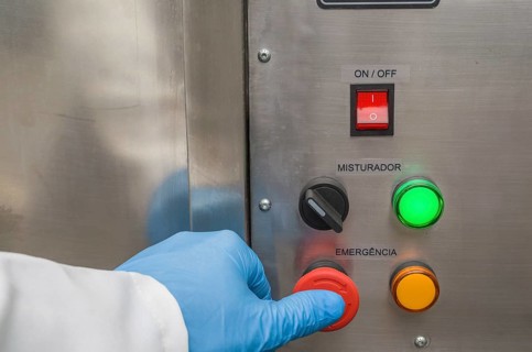 Great concept of emergency, person pushing the emergency button of production equipment