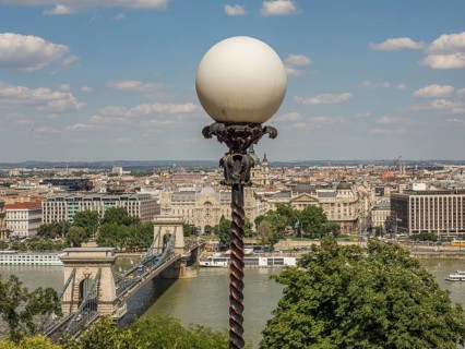 Street lamp with ball lamp and view of the cityscape and the river under a blue sky, budapest,