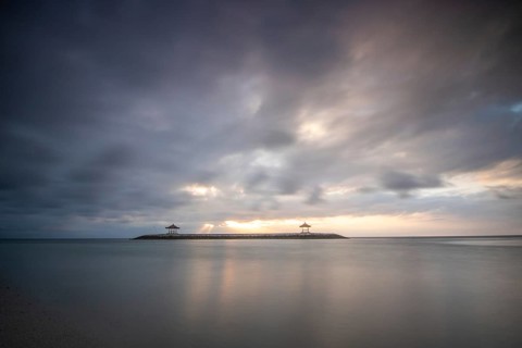 Beautiful seascape in the morning. Tropical sandy beach with breakwater and reflection of the sky