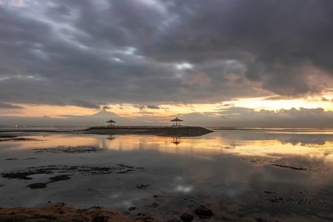 Beautiful seascape in the morning. Tropical sandy beach with breakwater and reflection of the sky