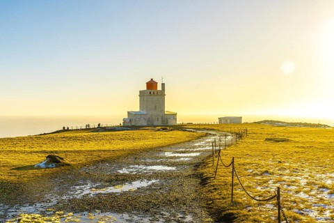 Famous lighthouse at sunset on Dyrholaey beach in Iceland in cold winter, near Vik