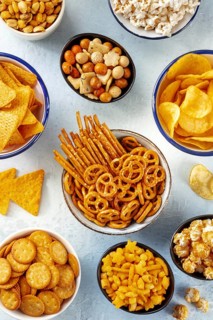 Salty snacks, party mix. A variety of crispy appetizers, shot from the top. Tortilla and potato
