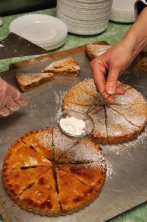 Cook sprinkling icing sugar on delicious homemade apple pies