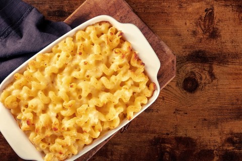 Macaroni and cheese pasta in a casserole, shot from the top on a rustic background with copy space,