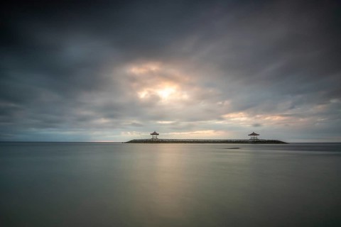 Beautiful seascape in the morning. Tropical sandy beach with breakwater and reflection of the sky
