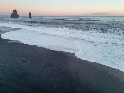 Aerial drone view of Reynisfjara black sand beach at sunset in Iceland