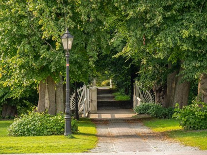Park path with trees, lantern and bridge, dornum, east frisia, germany
