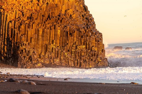 Beautiful on the black sand beach of Reynisfjara at sunset in Iceland