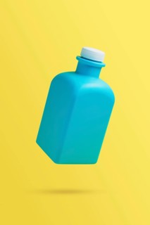 Levitation, flying blank cleaner blue bottle. Isolated on yellow background. Plastic packaging.