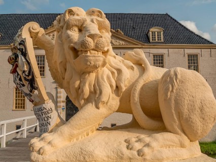 Lion statue with coat of arms in close-up in front of a historic building, dornum, east frisia,