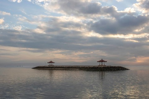 Beautiful seascape in the morning. Tropical sandy beach with breakwater and reflection of the sky
