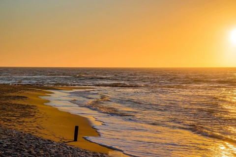 Den Helder, Netherlands. January 2022. Setting sun on the beach of Den Helder, Netherlands.