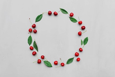 Gray concrete flat lay with big sweet cherries on table background. Top view on huge, massive