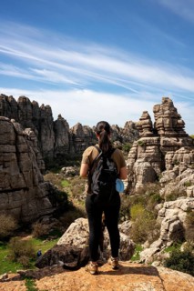 Woman looking at limestone rock formations in El Torcal de Antequera nature reserve, in Spain