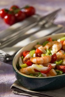 Shrimp salad with squid tomatoes celery inside an oval bowl