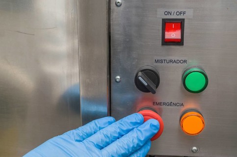 Great concept of emergency, person pushing the emergency button of production equipment