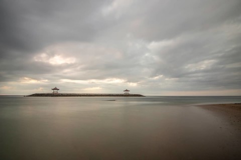 Beautiful seascape in the morning. Tropical sandy beach with breakwater and reflection of the sky