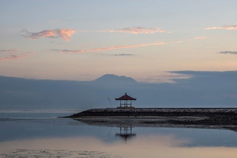 Beautiful seascape in the morning. Tropical sandy beach with breakwater and reflection of the sky