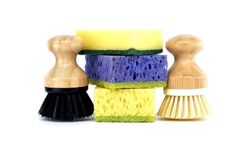 Three sponges, each a different color purple, yellow, and blue and two brushes with wooden handles