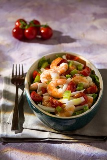 Salad of shrimps with squid tomatoes celery inside an oval bowl