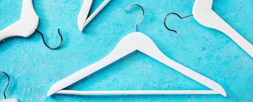 Fashion collection panorama. White wooden hangers, a flat lay layout on blue. Shopping background,