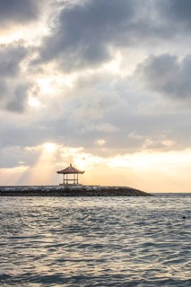 Beautiful seascape in the morning. Tropical sandy beach with breakwater and reflection of the sky