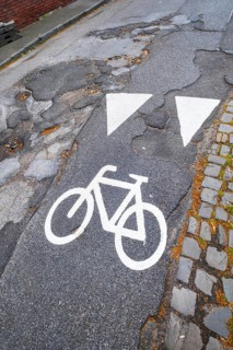 A cycle path pictogram on a road with potholes in Mönchengladbach, Germany, Europe