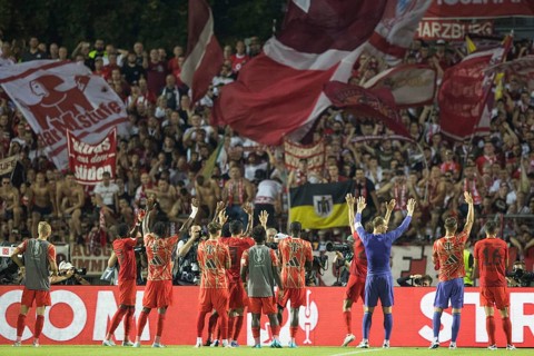 Football match, the team of FC Bayern Munich with raised hands in the curve after the victory to