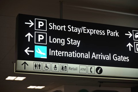 Airport signage directing passengers to parking areas and domestic flights