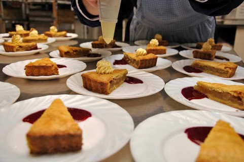 Cooks adding cream to delicious homemade apple pies