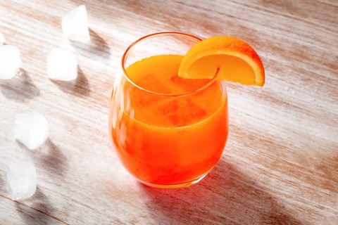 Orange drink on a wooden background, fresh pressed juice with a fruit slice and ice, Food