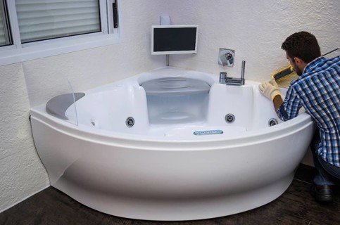Installation of modern bath, (hot tub), applying sealant, bathtub with tv