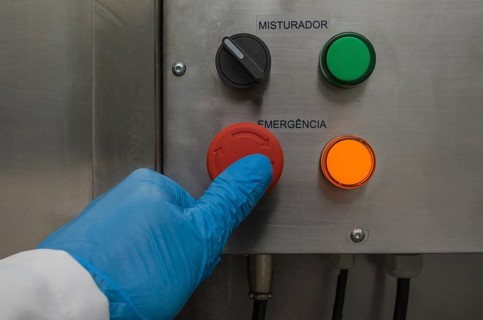 Great concept of emergency, person pushing the emergency button of production equipment