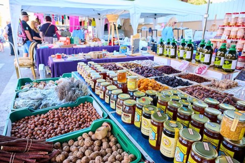 Market stall with honey und nuts and vegetables on a weekle market near Tarragona, Catalonia,