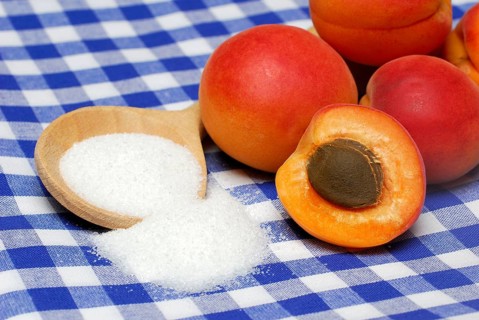 Apricots ( Prunus armeniaca) , Cooking spoon with sugar