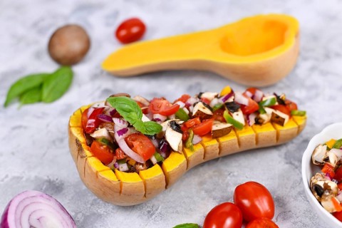 Vegan baked Butternut squash vegetable filled with bell pepper, cherry tomatoes, red onion and