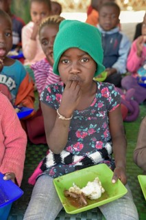 Child eats rice from plastic plate, Preschool for orphans, Katutura district, Windhoek, Khomas