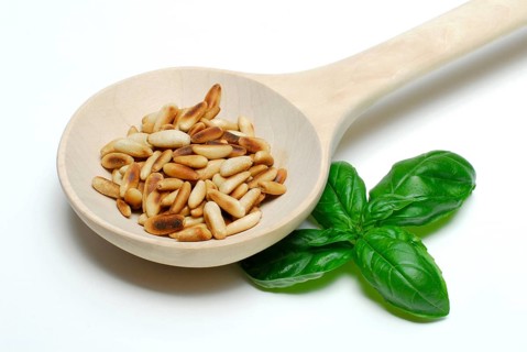 Roasted seeds (Pinus pinea) in wooden ladle, wooden spoon, wooden spoon