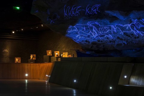 Replica of part of the Lascaux cave showing with black light prehistoric animals incised in the