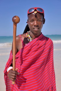 Young Maasai man wearing traditional dress and sunglasses on the beach, Dongwe Beach, Dongwe,