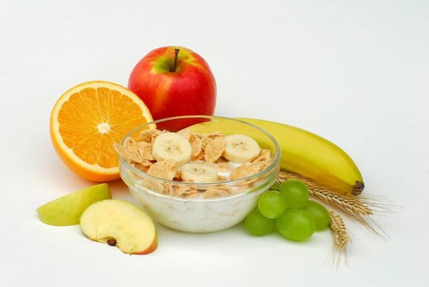 Muesli with milk in shell, apple, banana, orange, grapes, muesli