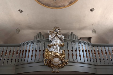 Figure of St. Nepomuk in front of the organ loft in the parish church of St. James the Elder, built