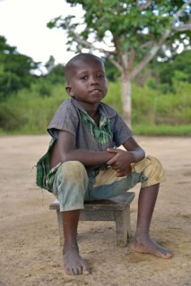 Boy sitting on a stool, Nkala, Bandundu Province, Democratic Republic of the Congo