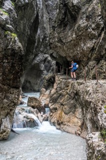 Hiker in a gorge, Hammersbach flows through Höllentalklamm, near Garmisch-Partenkirchen,