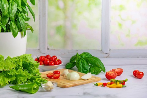 Fresh vegetables on a board, salad ingredients, tomatoes, lettuce, basil, pepperoni, onion, garlic,