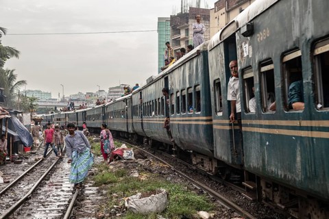 A train passes through an informal settlement built close to a railway line, Tejgaon Slum, Area,